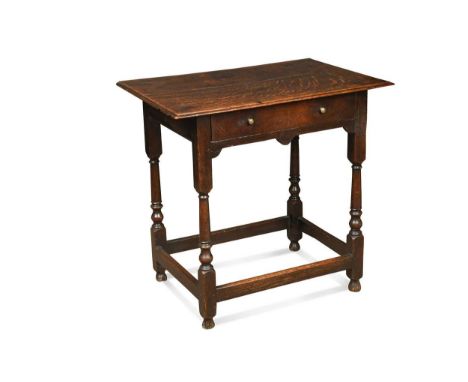 An oak lowboy, early 18th century, the two plank moulded top over a single frieze drawer raised on turned legs united by stre