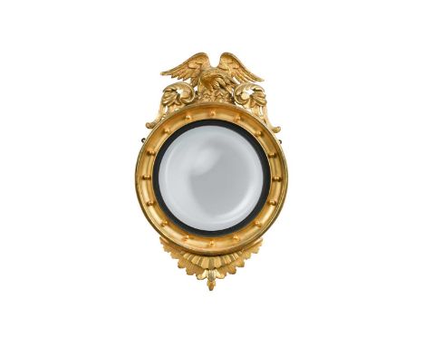 A carved giltwood convex wall mirror, 19th century, the mirrored plate within a ball mounted frame surmounted by an eagle91 x