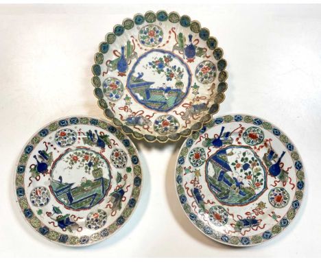 A pair of Chinese famille verte dinner plates, Qing Dynasty, Kangxi (1662-1722), painted with a little boy on a veranda withi