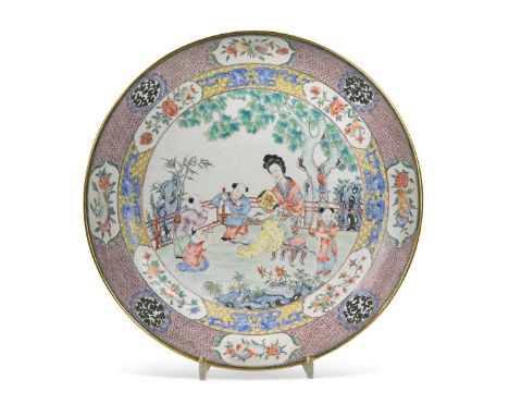 A Chinese famille rose Canton enamel dish, 20th century, painted with a lady and four boys on a garden veranda by a tree, wit