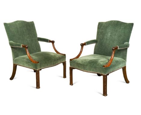 A pair of George III mahogany library armchairs, circa 1760, each with slightly arched rectangular padded backs above padded 