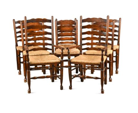 A set of eight oak George III style ladder back chairs, 20th century, to include two carvers, with drop in rush seats on turn