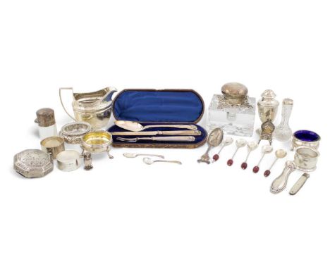 A mixed lot of silver items,comprising: a mounted glass inkwell, three salt cellars, a cream jug, a cased knife, fork and spo