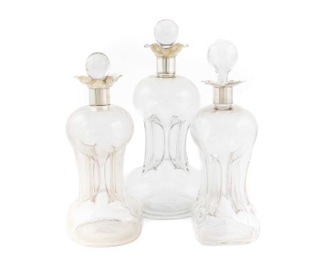 A silver-mounted glass decanter,by William Hutton and Sons, Birmingham 1928, hour-glass form, plain mount, plus two smaller s