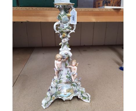 A late 19th Century continental porcelain cherub candlestick, Dresden style and hand painted, indistinct blue mark to base, 1