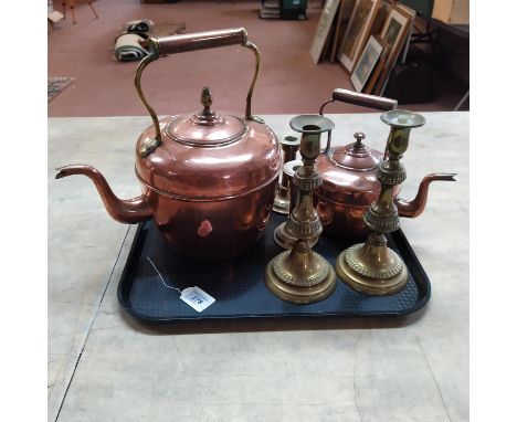 A large copper and brass kettle together with a small example and a large pair of brass candlestick together with a smaller p