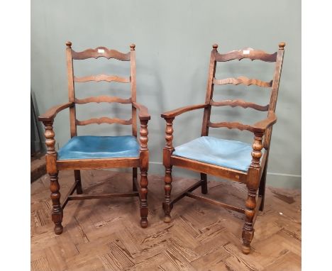 A pair of oak Jacobean style ladder back carver chairs