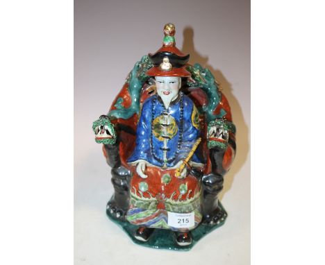 A CHINESE CERAMIC SEATED FIGURE