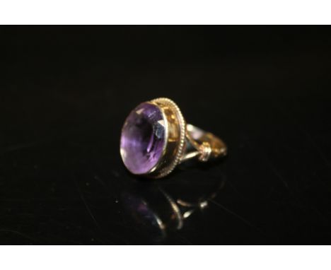 A LARGE AMETHYST DRESS RING, on yellow metal band stamped 9ct, the oval amethyst measuring approximately 16 x 12 mm, ring siz