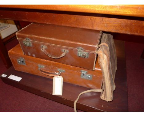 A tan leather vintage suitcase together with a smaller similar and a briefcase with straps 