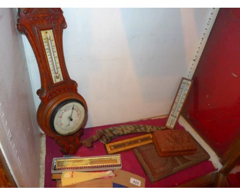An oak barometer, a carved teak book slide, an eastern dagger a collection of fans and other items 