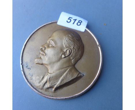 A gilded plaque having portrait of Lenin in relief