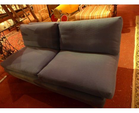 A contemporary sofa upholstered in blue fabric on block supports  