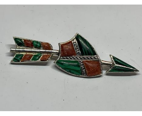 A GREEN AND RED STONE BROOCH DEPICTING A SHIELD AND ARROW 