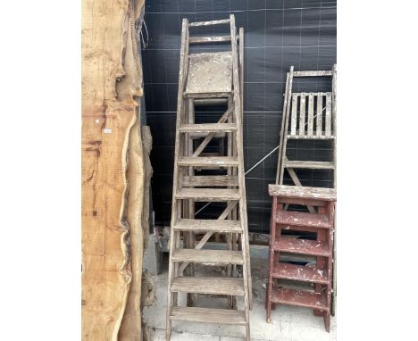 A VINTAGE 7 RUNG WOODEN STEP LADDER AND A FURTHER EXTENDING WOODEN LADDER 