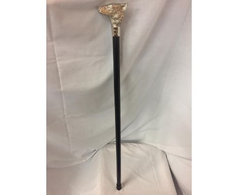 A WOODEN WALKING STICK WITH A WHITE METAL WOLF HEAD 