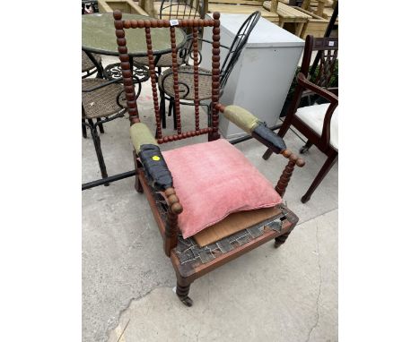 A 19TH CENTURY BOBBIN TURNED FIRESIDE CHAIR WITH SLOPING BACK, ON PORCELAIN/BRASS CASTERS 