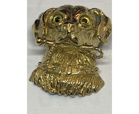 A SILVER GILT PENDANT IN THE FORM OF A DOGS HEAD WITH A STICK 