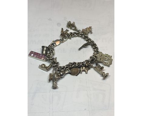 A SILVER BRACELET WITH THIRTEEN CHARMS A GENIE LAMP, LIVERPOOL FOOTBALL CLUB BADGE, ELEPHANT, VINTAGE PHONE, PISTOL ETC 