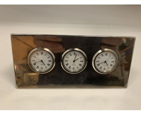 A TRIANGULAR PRISM SHAPED CHROME QUARTZ CLOCK WITH THREE FACES 