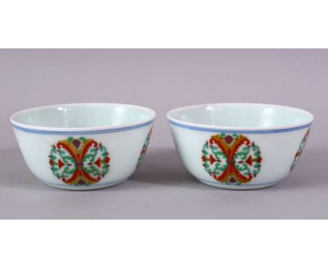 A PAIR OF CHINESE DOUCAI DECORATED PORCELAIN BOWLS, with roundel decoration depicting formal floral motif, the bases with sea