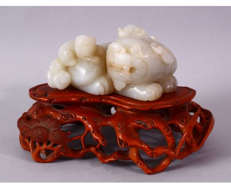 A GOOD CHINESE CARVED WHITE JADE FIGURE OF THREE LION &amp; BOXWOOD STAND, one larger dog with two young climbing upon, with 