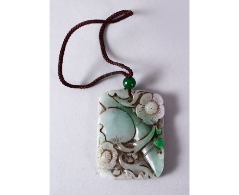 A 19TH/20TH CENTURY CHINESE CARVED JADE / JADEITE PENDANT, depicting a peach, prunus and bamboo, 5.5cm x 4cm.
