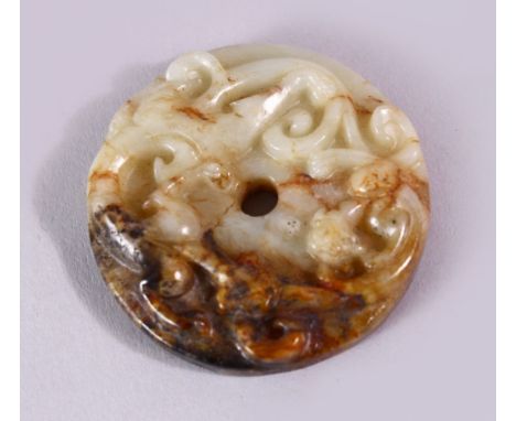 A 19TH CENTURY SPECKLED JADE CIRCULAR ROUNDEL, carved with scrolls, 4.5cm diameter.