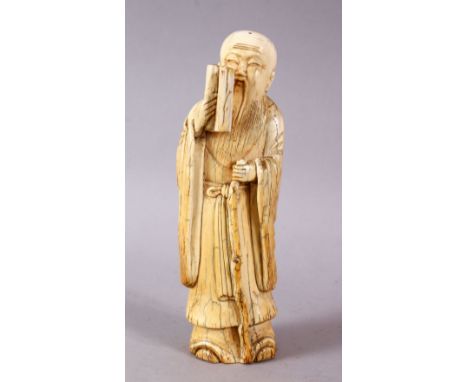 A 17TH / 18TH CENTURY CHINESE CARVED IVORY FIGURE OF A SCHOLAR, stood holding a scroll and his stick, in traditional dress, 1