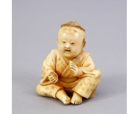 A JAPANESE MEIJI PERIOD CARVED IVORY NETSUKE OF A BOY, the boy in a seated position clapping his hands togeether, the base wi