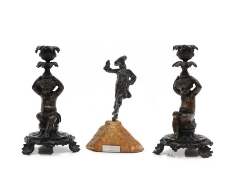 A pair of bronze candlesticks, late 19th century, each column in the form of a crouching putti holding a sconce aloft, 21.5cm