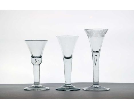 A group of three 18th century wine glasses c.1740, the first with a trumpet form bowl engraved with a fruiting vine border, o
