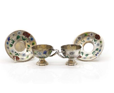 Two sets of silver and enamelled teacups and saucers  marked 'A', with enamelled floral decoration, the teacup handles modell
