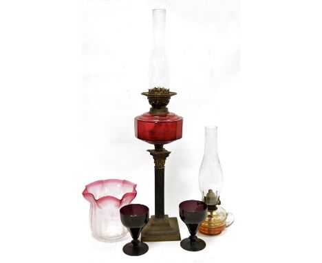 Victorian brass and cranberry glass oil lamp having panelled glass oil well, on corinthian column stand and with etched and f