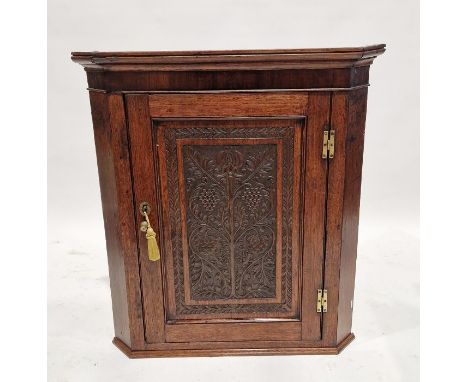 Georgian oak wall hanging corner cabinet with later carved panel to the door of grape and vine motifs, measuring approx. 94cm