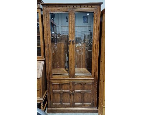 Modern stained oak display cabinet, the two doors fitted with bevel-edged glass panels and having four adjustable wooden shel