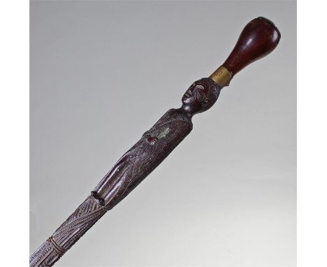 Rare 19th Century New Zealand Toko Toko stick, the tapering stick with carved figure in long jacket, alone set eyes, arm acro