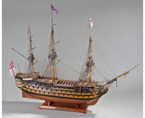 Large model of HMS Victory, sails down, fully rigged, canons to each side, raised on a shaped base, 103cm long