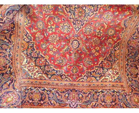 A fine central Persian Kauhan carpet, central double pendent medallion with repeating petal motifs on a rouge field within sa