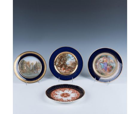 Beautiful collection of decorative plates rimmed in cobalt blue and gold. Three depict outdoor scenes. One has rust and gold 