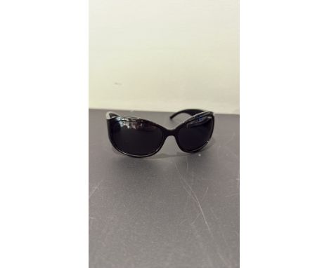 Black Polaroid polarized sunglasses, oval wraparound lenses, glossy acetate frame with rhinestone-set vertical motif at hinge