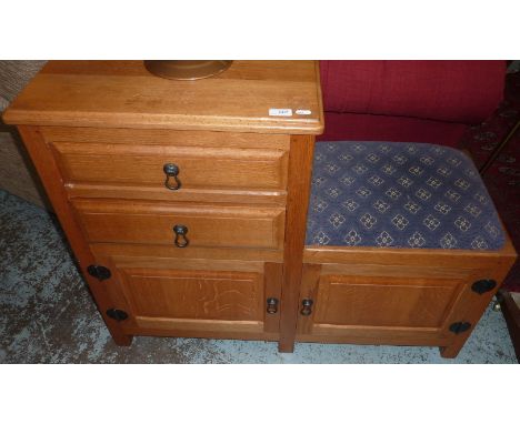 Light oak Mouseman style telephone table with 2 drawers above cupboard door, upholstered seat and further cupboard door