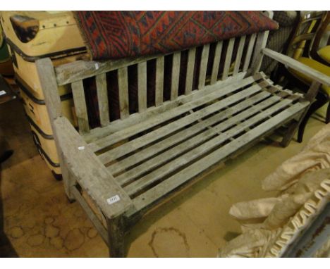 A weathered hardwood slatted garden bench