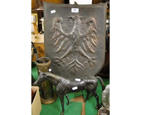 A copper German eagle emblem plaque, a brass easel, a pipe, and a brass horse.