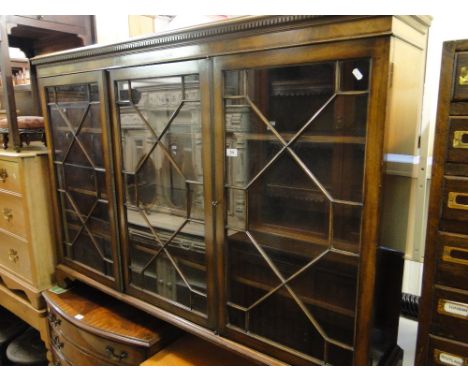 A mahogany bookcase with 3 lattice glazed doors, bracket feet.