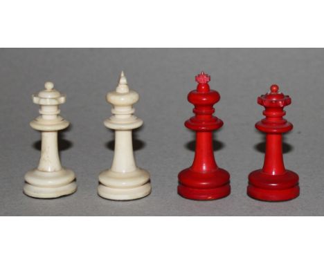 Europa. Schachfiguren aus Bein im Staunton – Stil mit Spielkasten aus Holz. Eine Partei in rot, die andere naturfarben. Produ