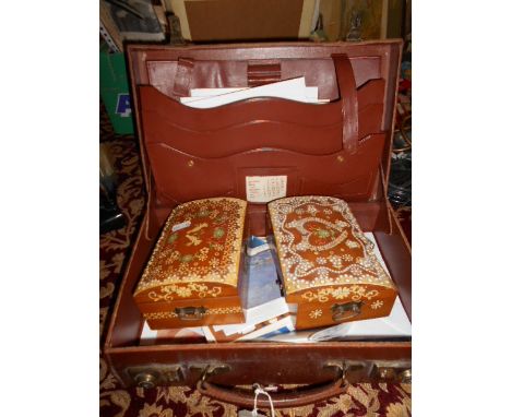 A small leather suitcase and two tourist trinket boxes