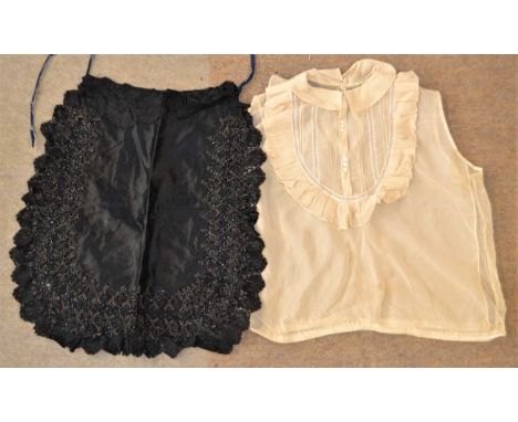An early 20th century sleeveless bib front lace blouse, with small collar, lace trim and ruffled bib front, sleeveless with n