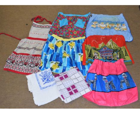 A quantity of vintage cotton printed hostess / cocktail aprons and printed tablecloths