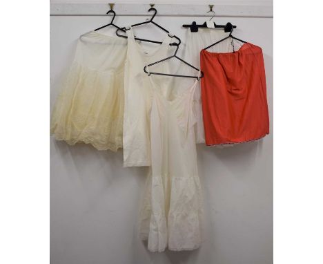 A quantity of vintage underwear to include a mid 20th century V-neck slip, two mesh underskirts, a red slip, and a cotton ves